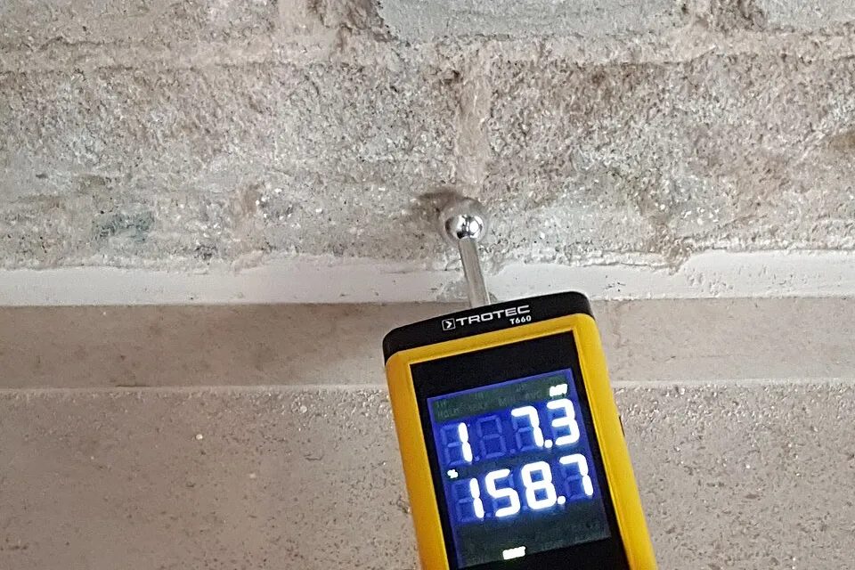 Moisture meter checking a masonry surface